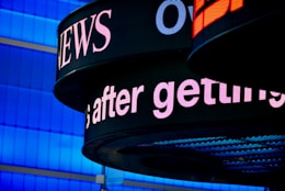 a close up of a sign with a building in the background