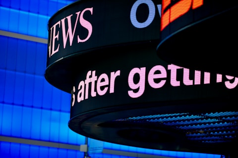 a close up of a sign with a building in the background