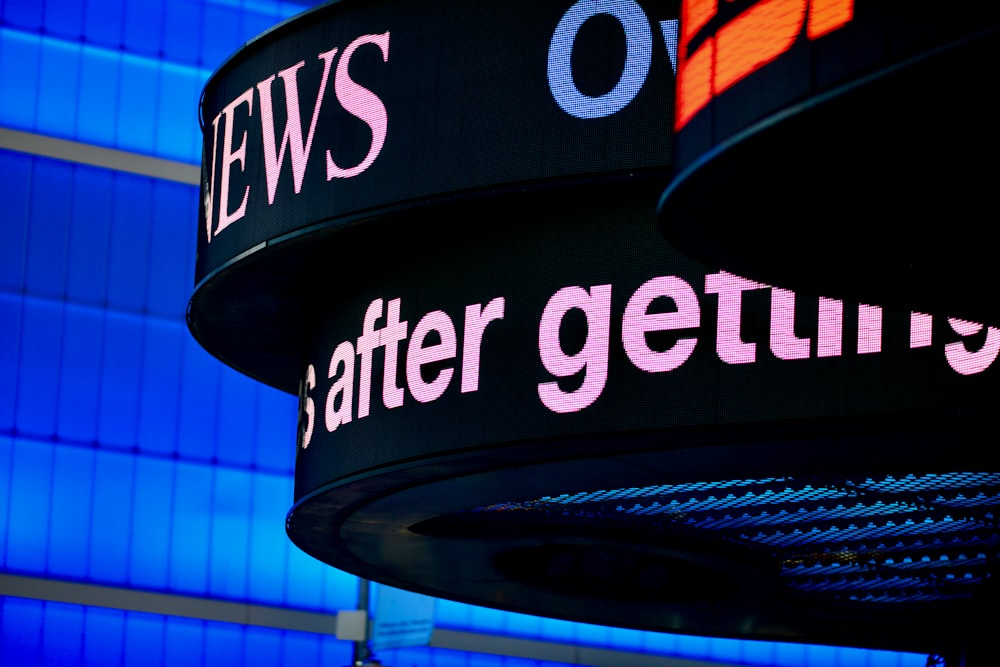 a close up of a sign with a building in the background