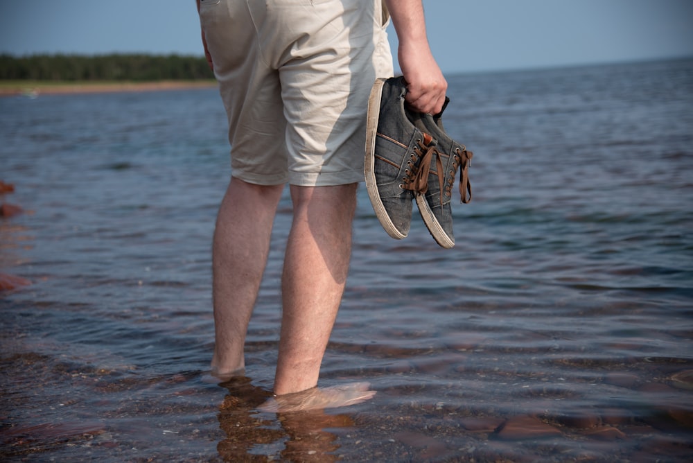 a person standing in the water with a shoe
