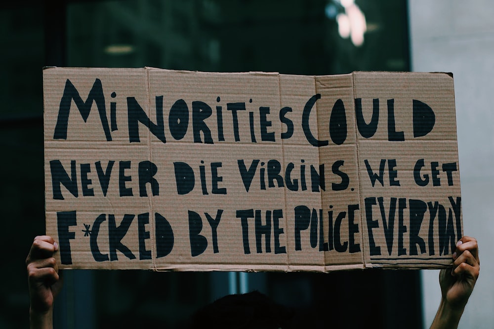a person holding up a sign that says minorityities could never die virgins we