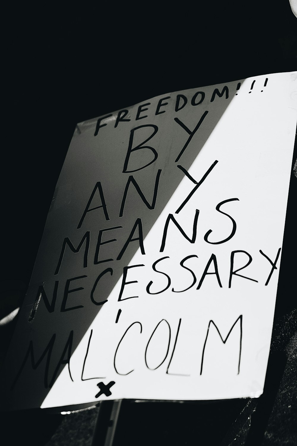 una persona sosteniendo un cartel con escritura en él