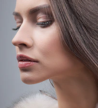 a woman with long hair and a fur collar