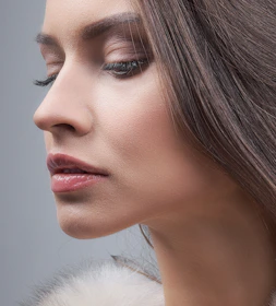 a woman with long hair and a fur collar