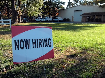 a now hiring sign in front of a building