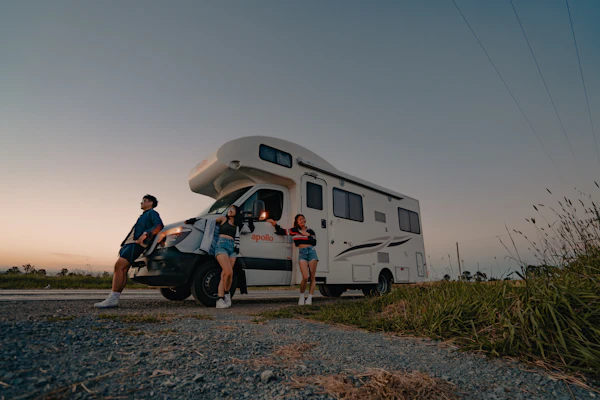 Family group beside a parked premium caravan on a Rajasthan road trip from Jaipur