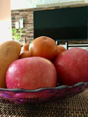 Nutritional consultation in progress with the practitioner jotting notes beside a fresh fruit bowl.