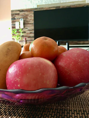 Nutritional consultation in progress with the practitioner jotting notes beside a fresh fruit bowl.
