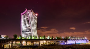 Modern luxury residential tower overlooking a vibrant city skyline at dusk