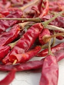 a pile of red peppers sitting on top of a table