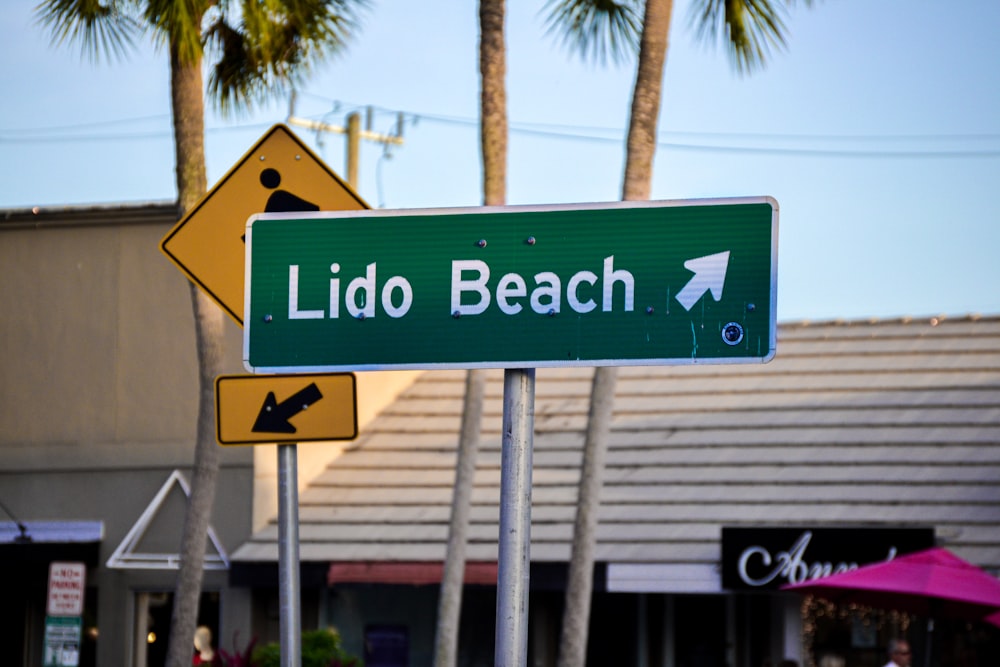 uma placa de rua que diz lido praia sobre ele