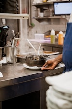 a person standing in a kitchen preparing food