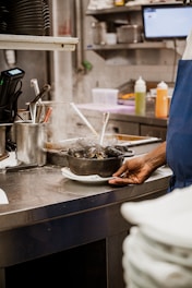 a person standing in a kitchen preparing food
