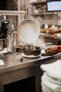 A vibrant cooking class scene with guests learning to prepare fresh seafood dishes in a rustic kitchen.