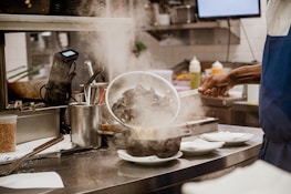 a person in a kitchen cooking food on a stove