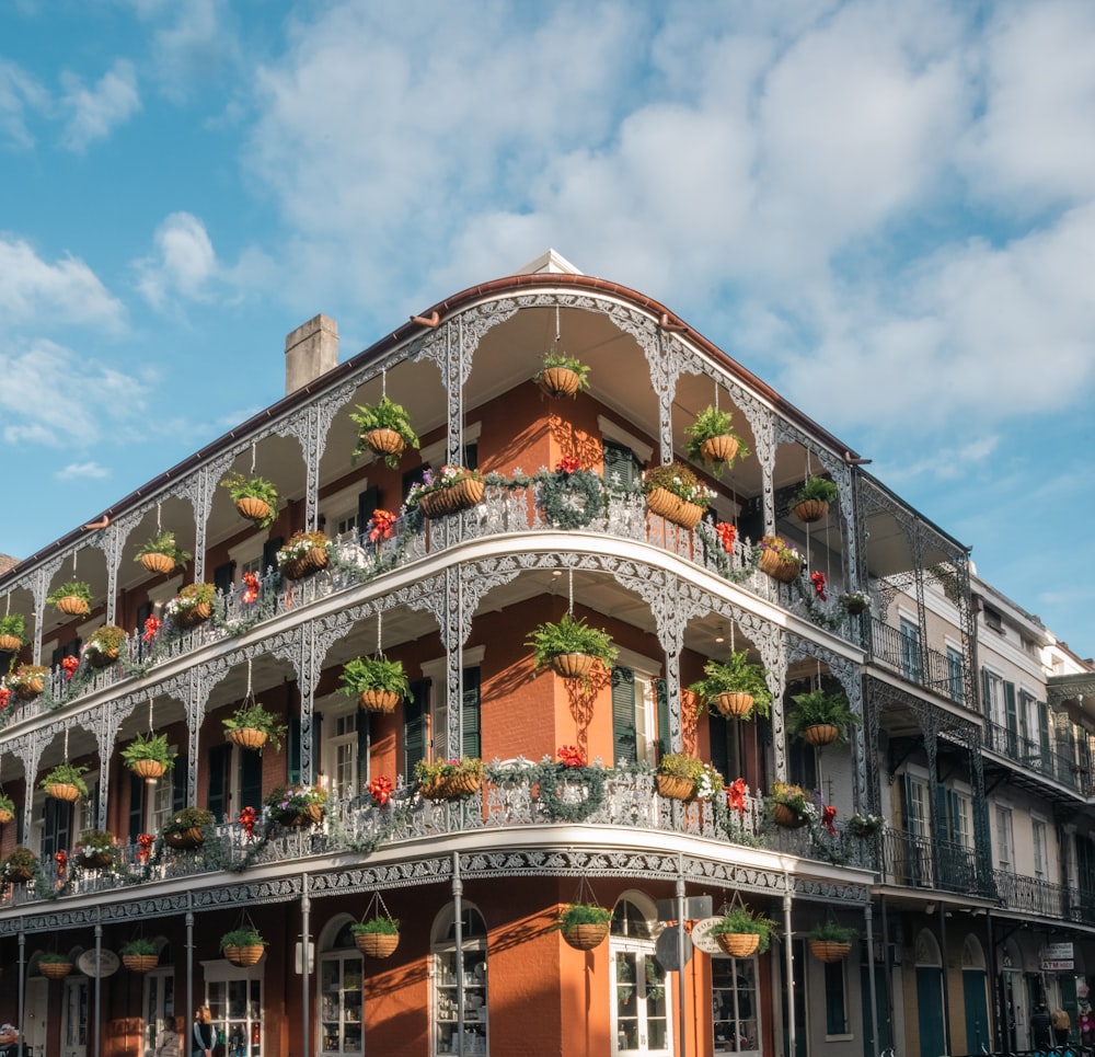 Un edificio alto con balcón y flores en los balcones