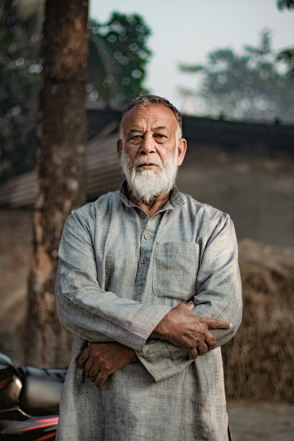 an old man with a white beard standing in front of a motorcycle