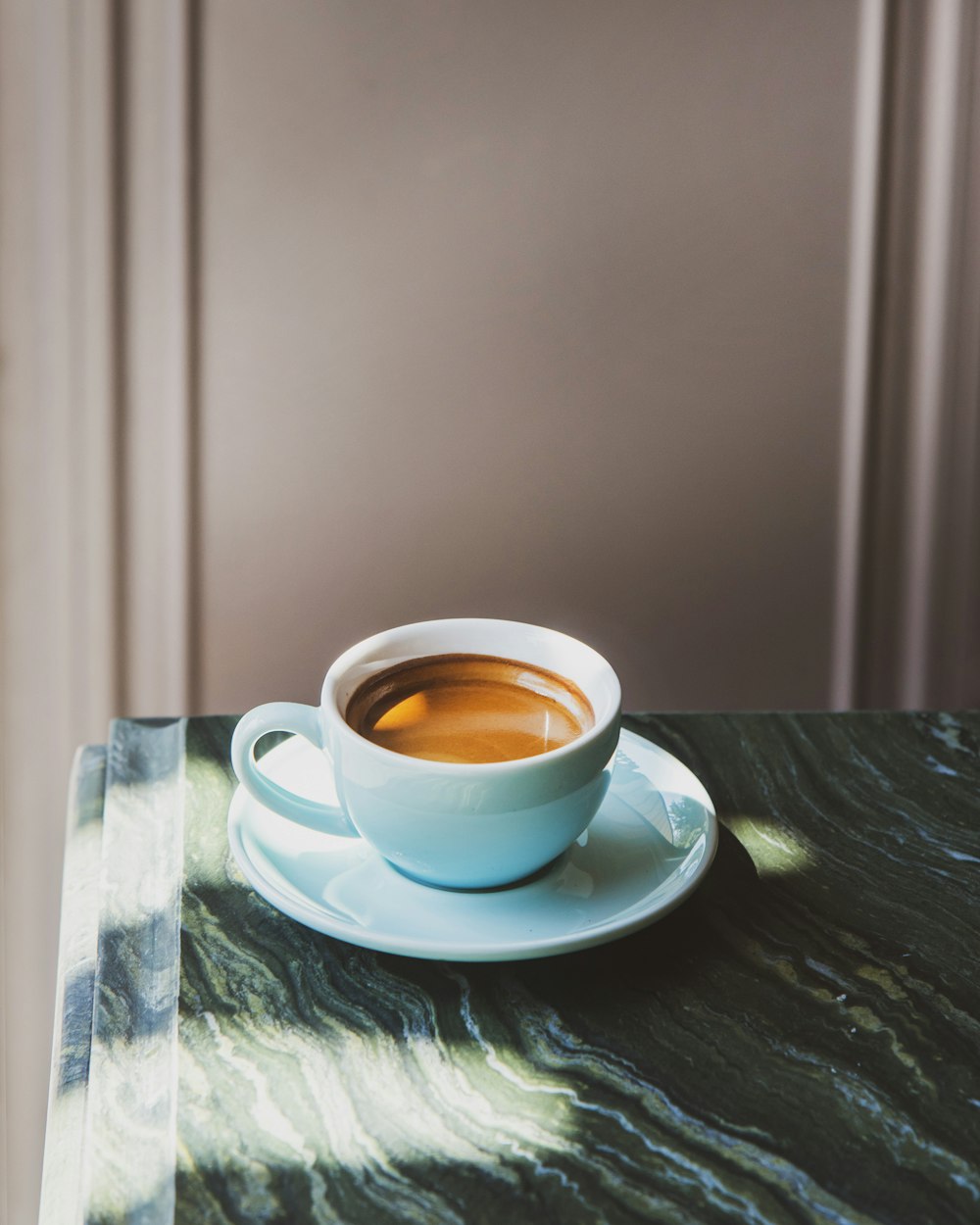 una tazza di caffè seduta sopra un piattino