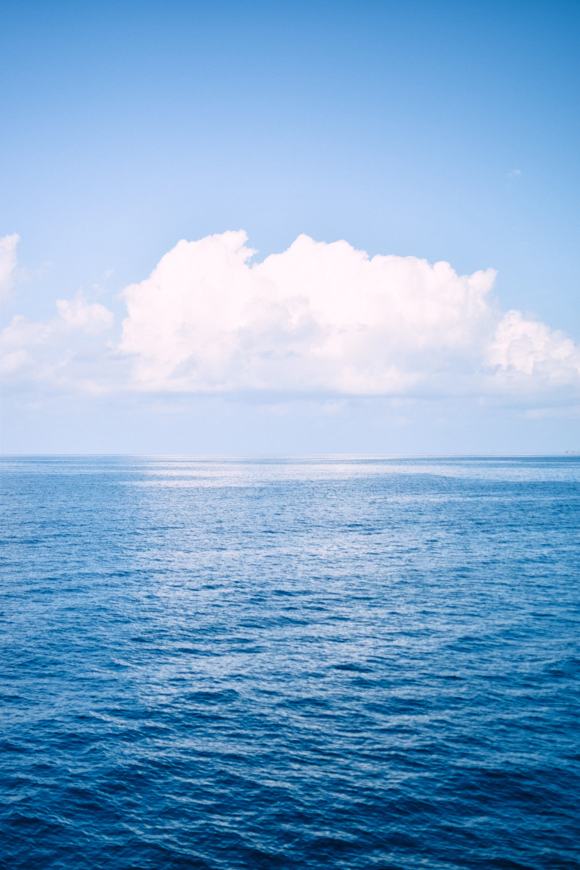 a large body of water under a cloudy blue sky