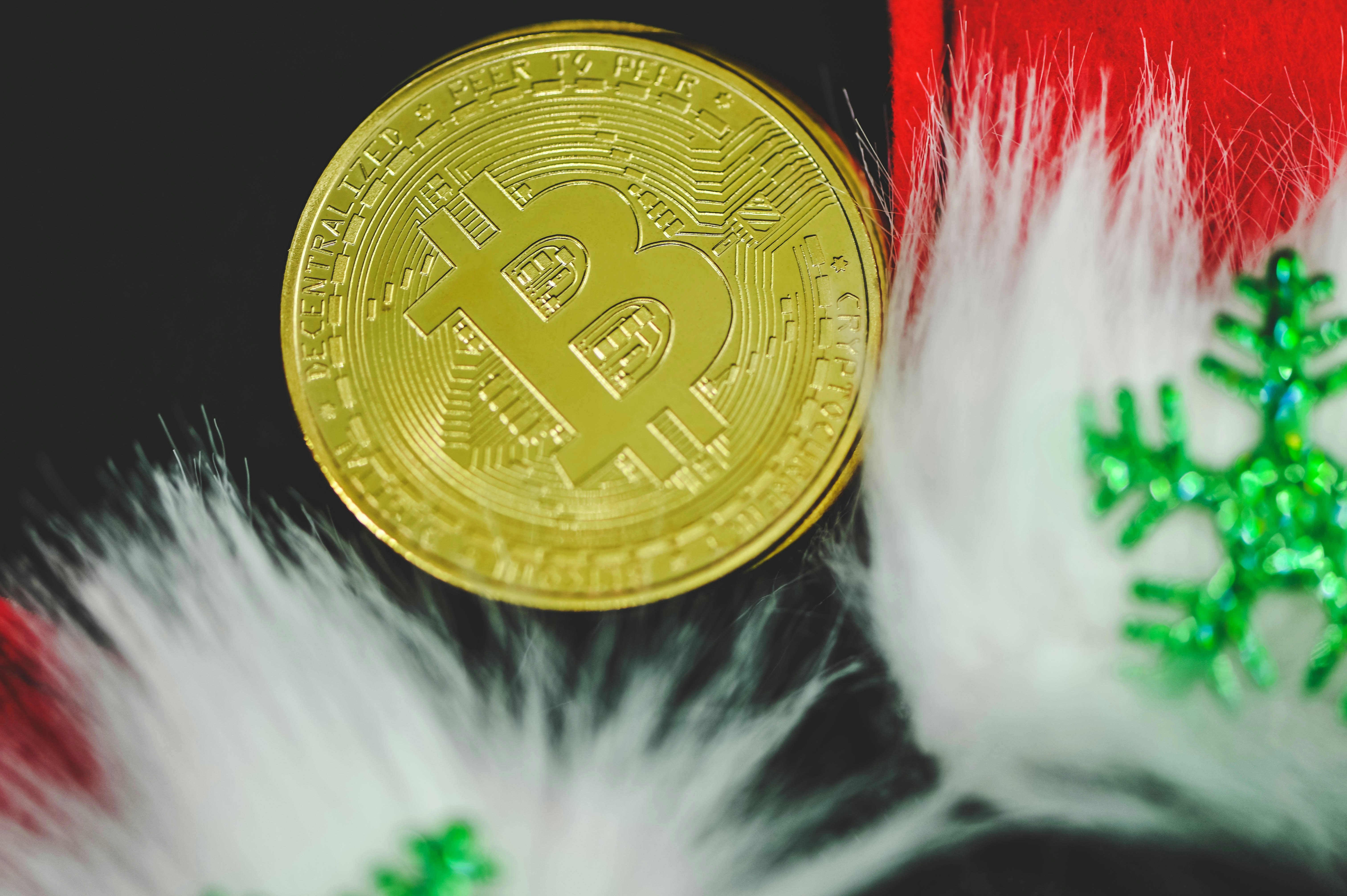 Bitcoin in between two Christmas ornaments on a black background