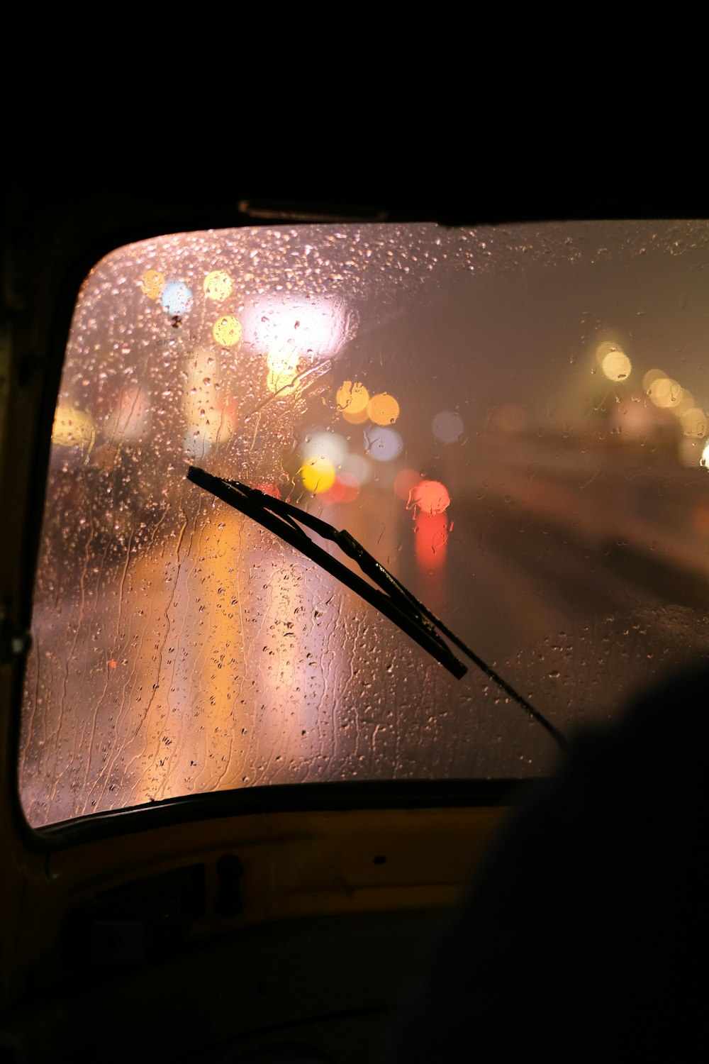 a windshield with rain drops on it at night