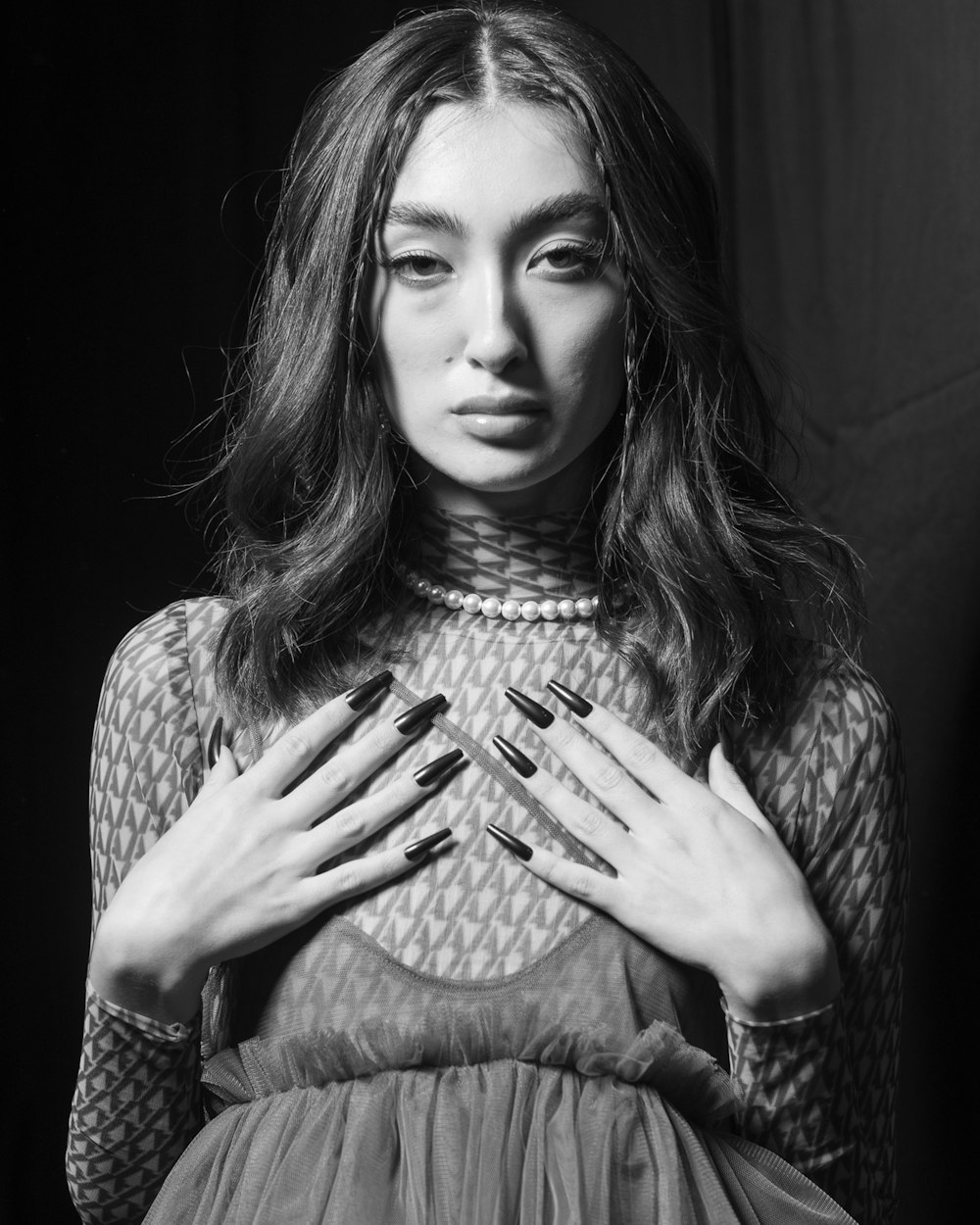 a black and white photo of a woman with her hands on her chest