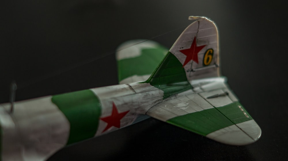 a green and white model airplane on a table