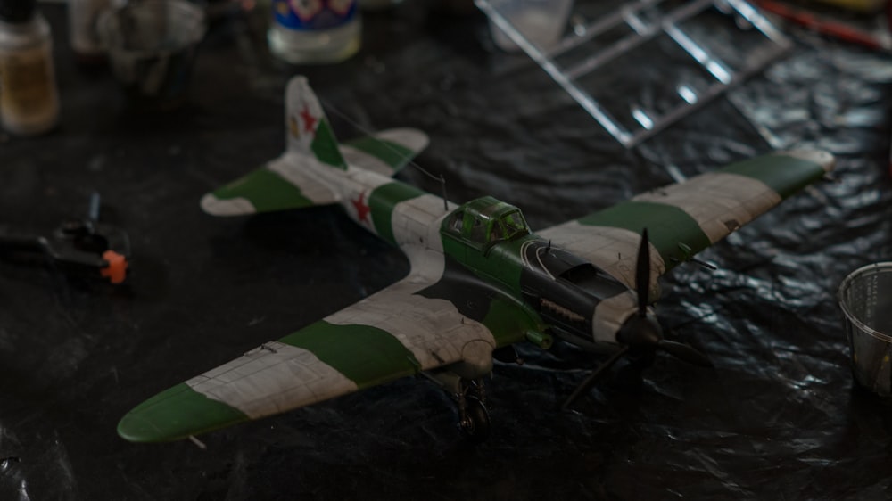 a green and white model airplane on a table