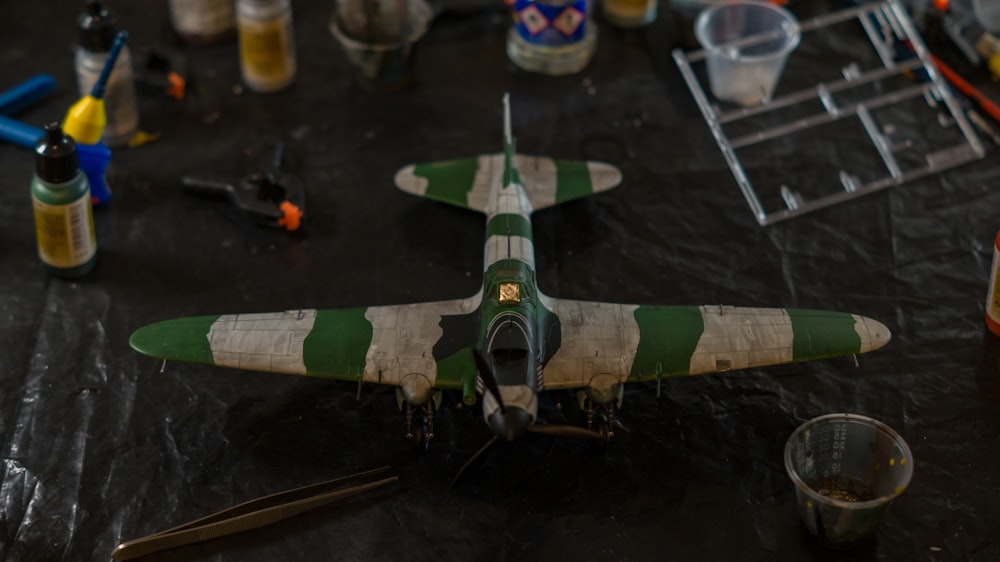 a green and white model airplane sitting on a table