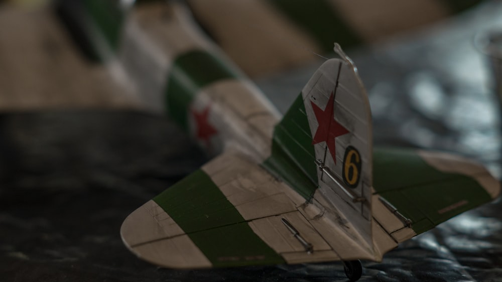 a green and white model airplane on a table