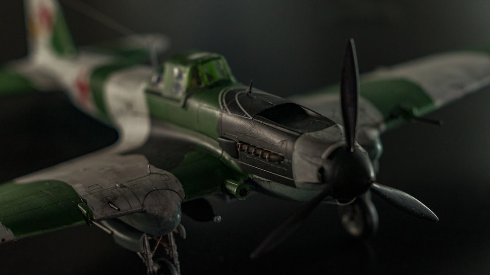 a green and white model airplane on a table