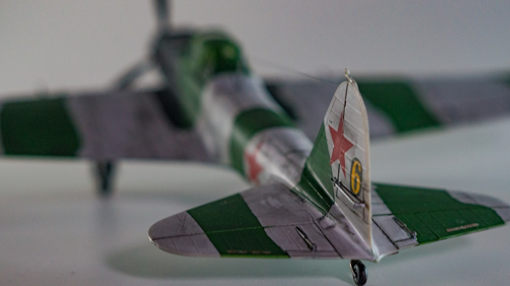 a green and white model airplane on a table