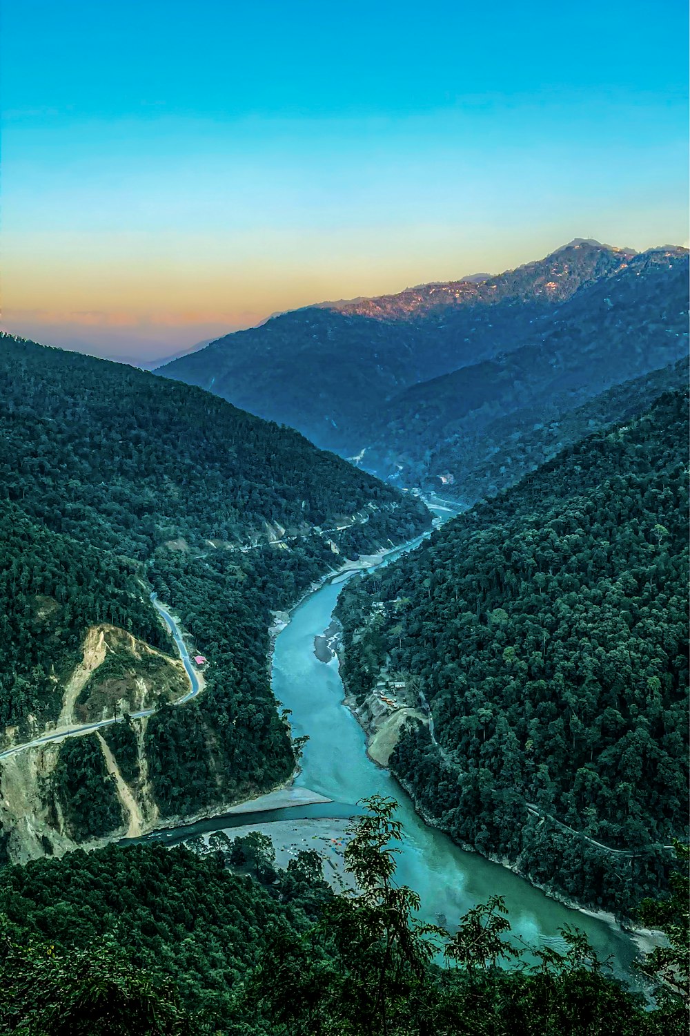 a river flowing through a lush green valley