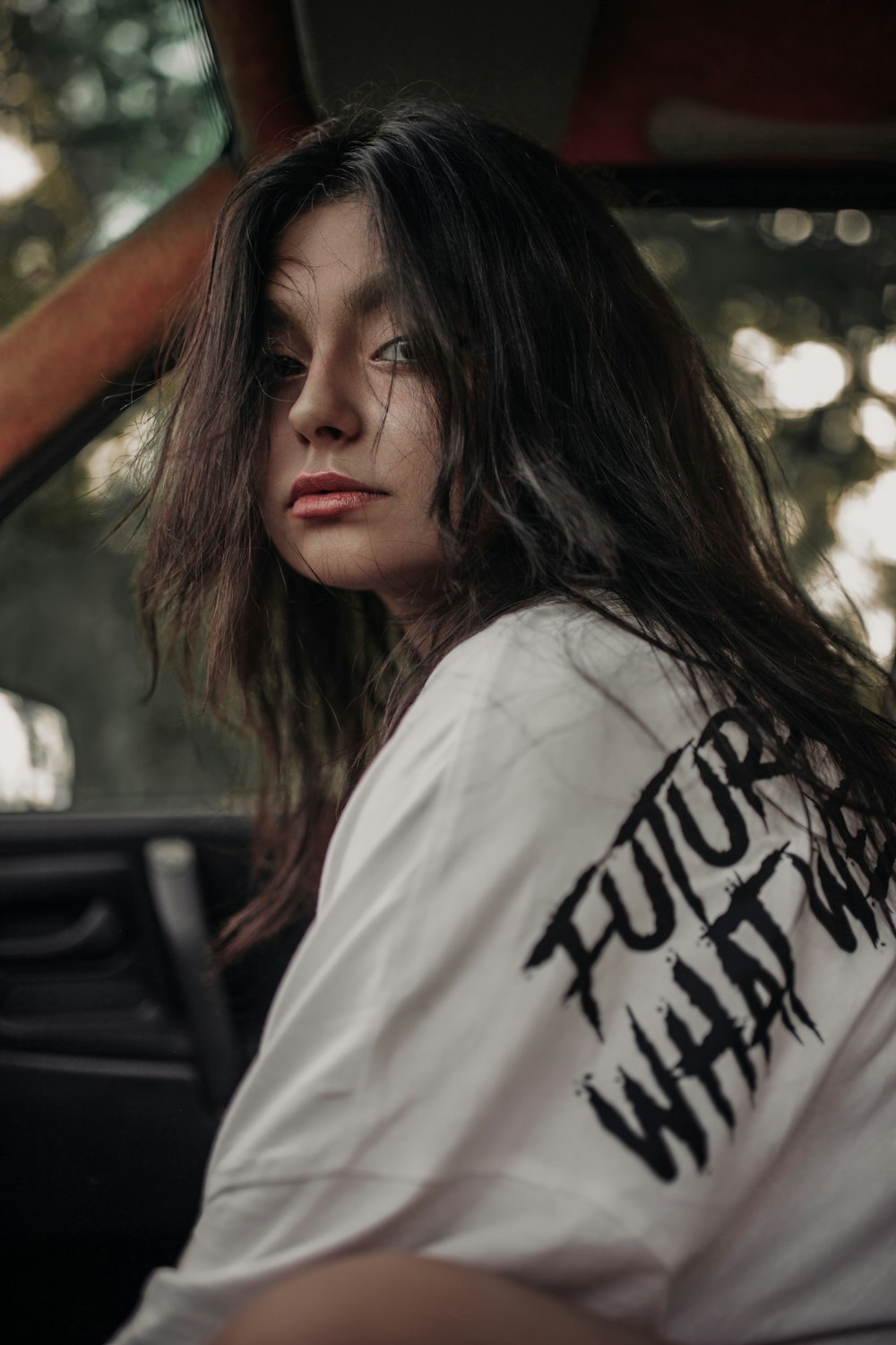 a woman with long hair sitting in a car