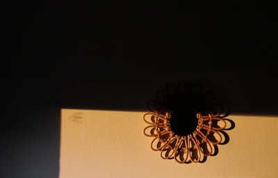 Close-up of a detailed macrame wall hanging casting soft shadows on a sunlit wall.