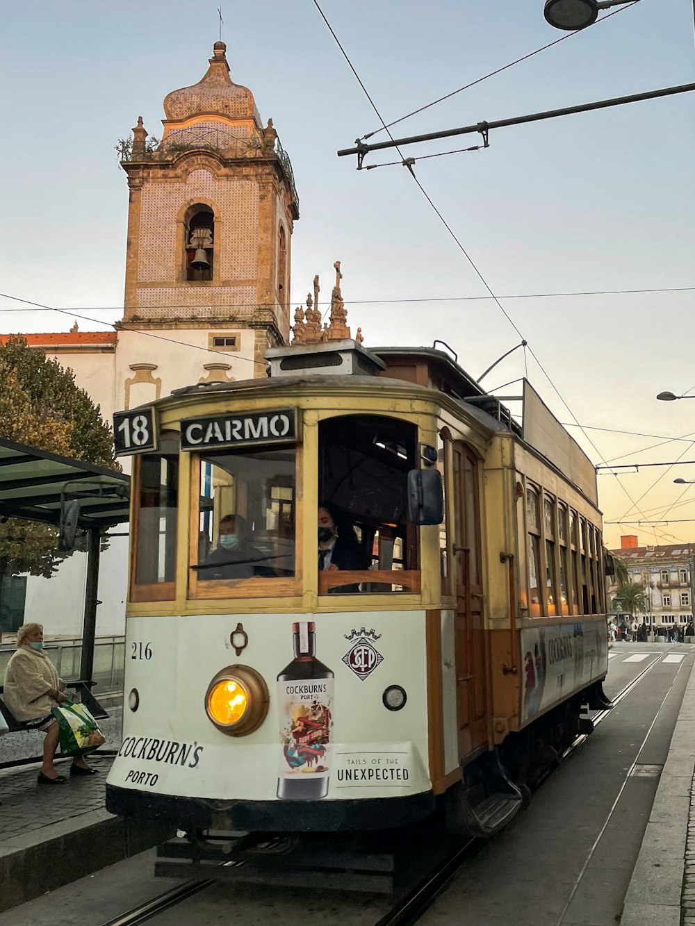 a trolley car on a city street with a clock tower in the background