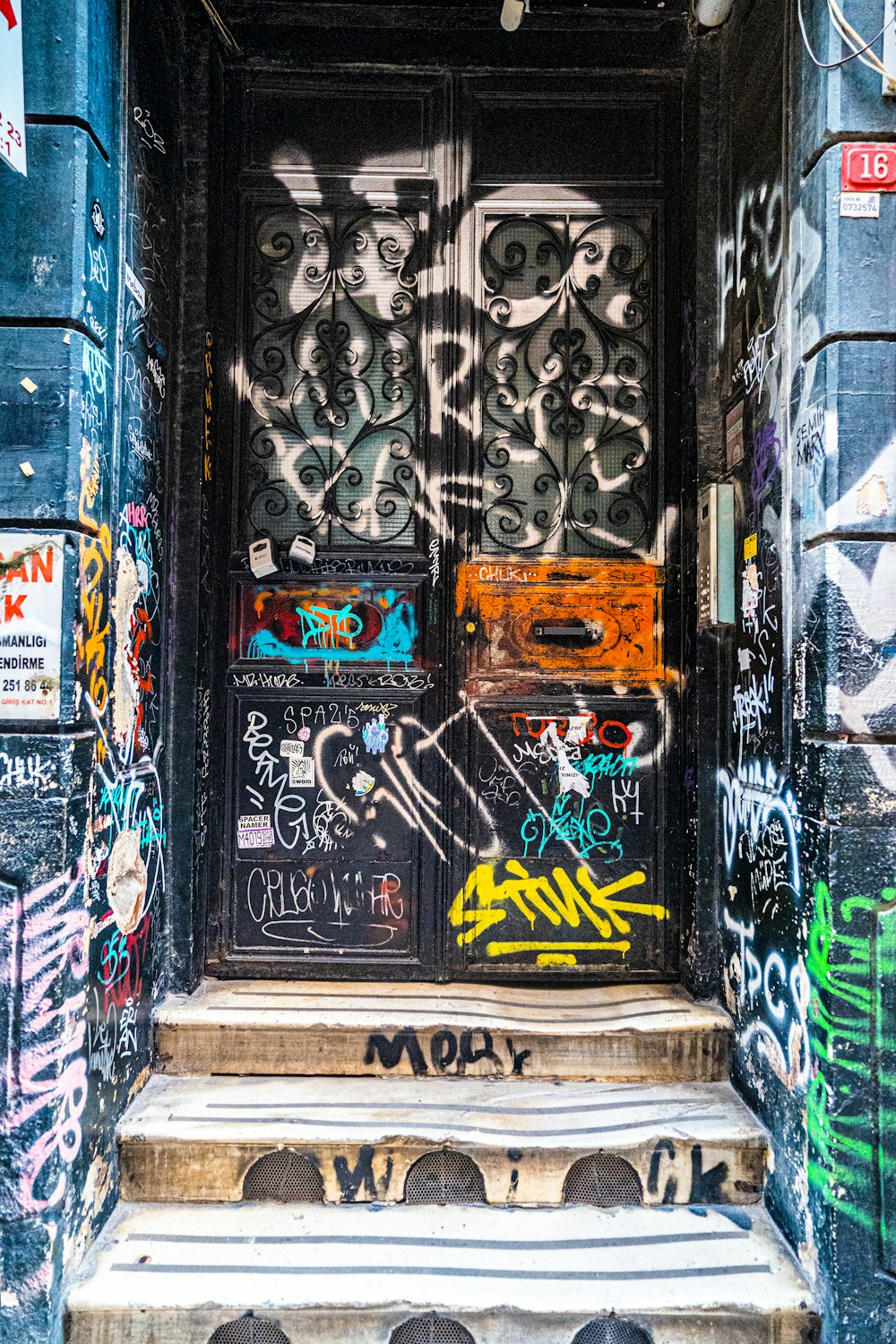a door covered in graffiti and spray paint