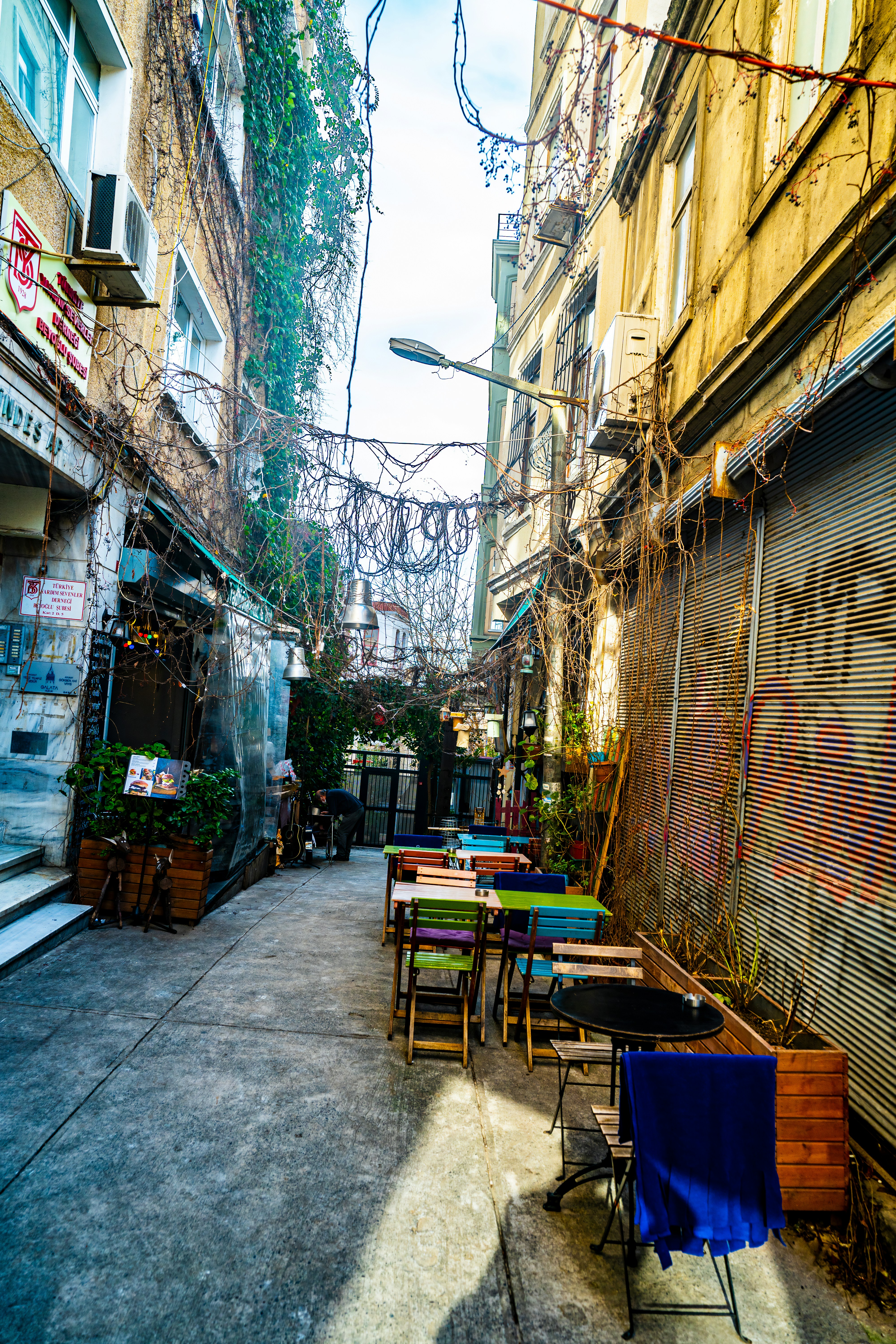 a narrow alleyway with tables and chairs