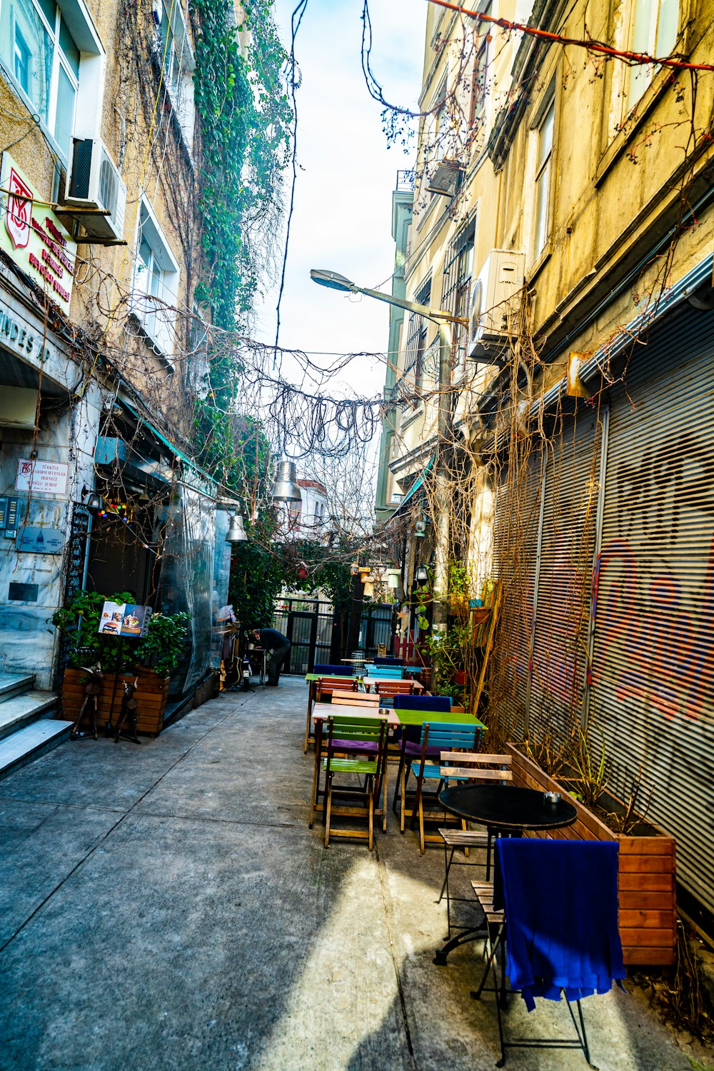 a narrow alleyway with tables and chairs