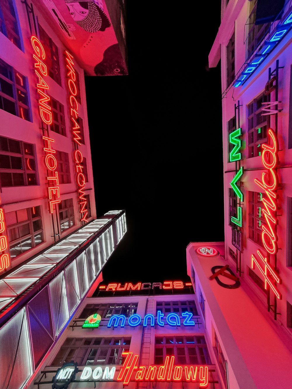 a view of a very tall building with neon signs on it