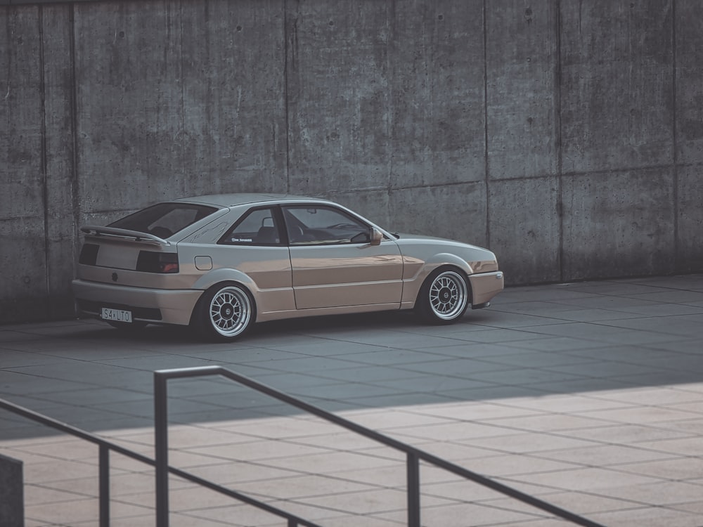 a car parked in front of a concrete wall