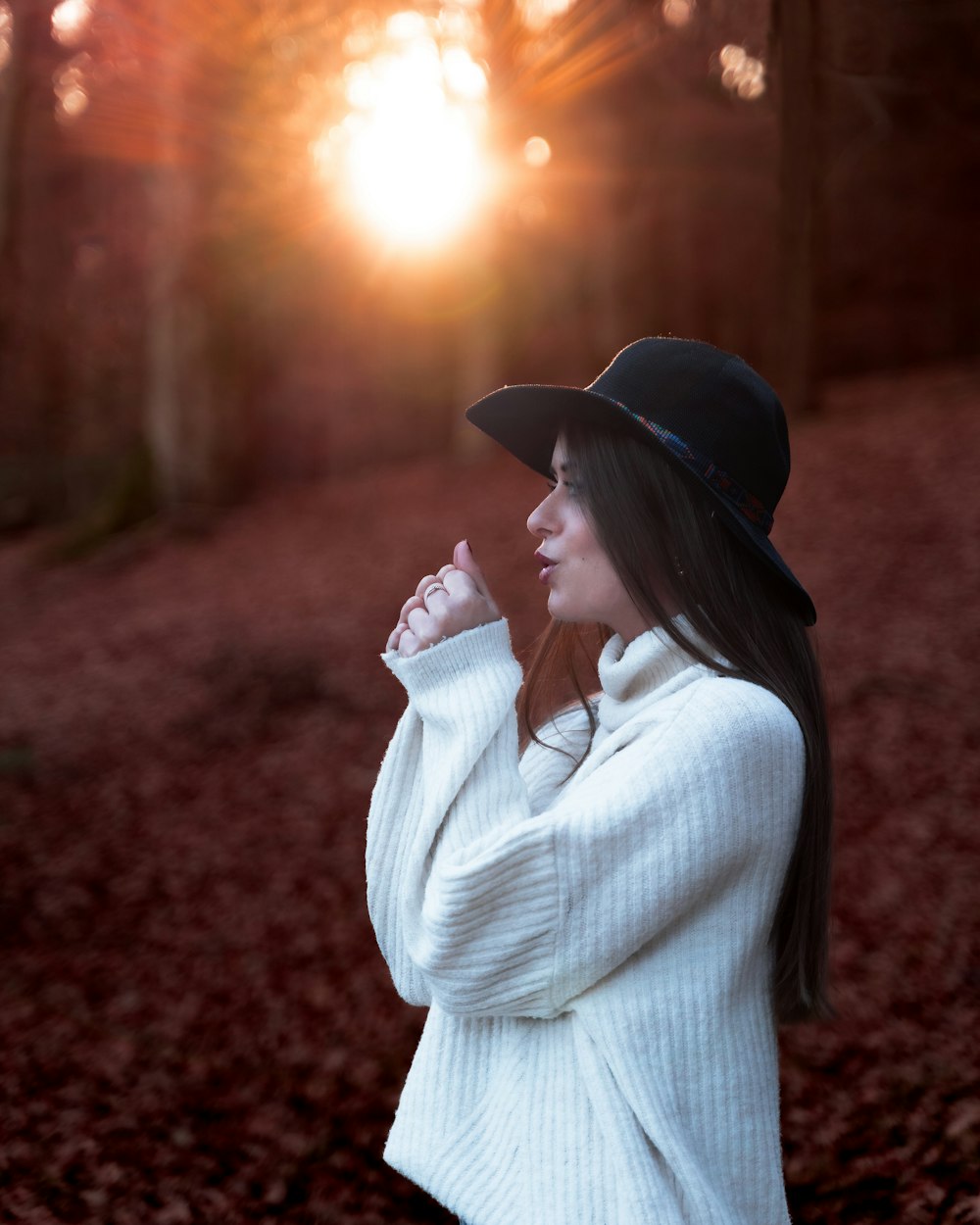 a woman in a white sweater and black hat