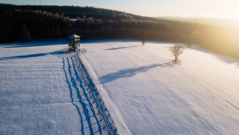 a field covered in snow next to a forest