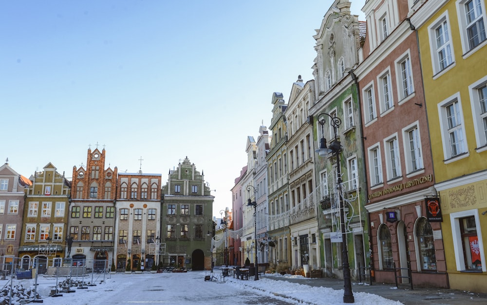 a row of buildings on a street with snow on the ground