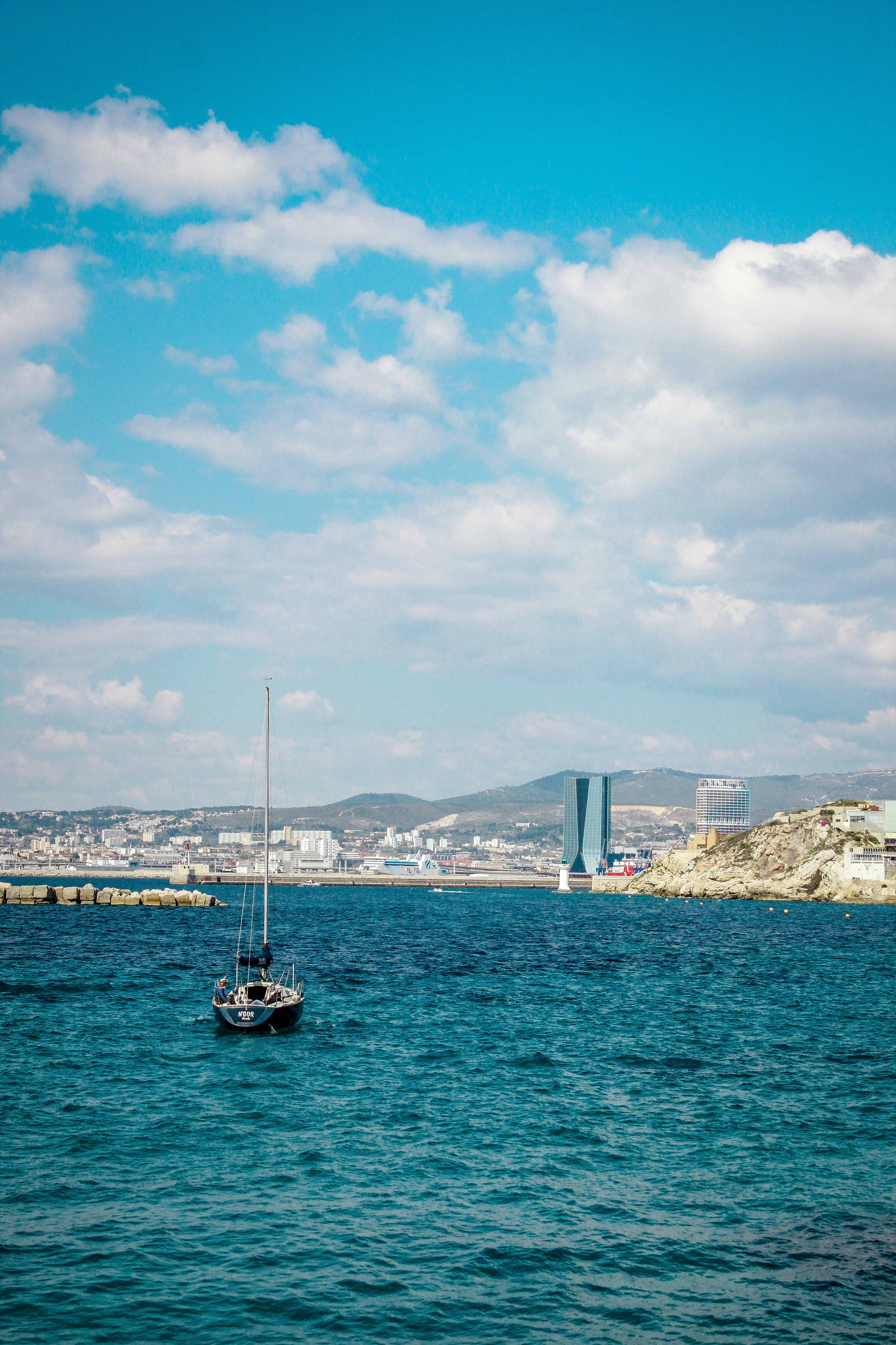 Una barca a vela che galleggia in mezzo a un grande specchio d'acqua