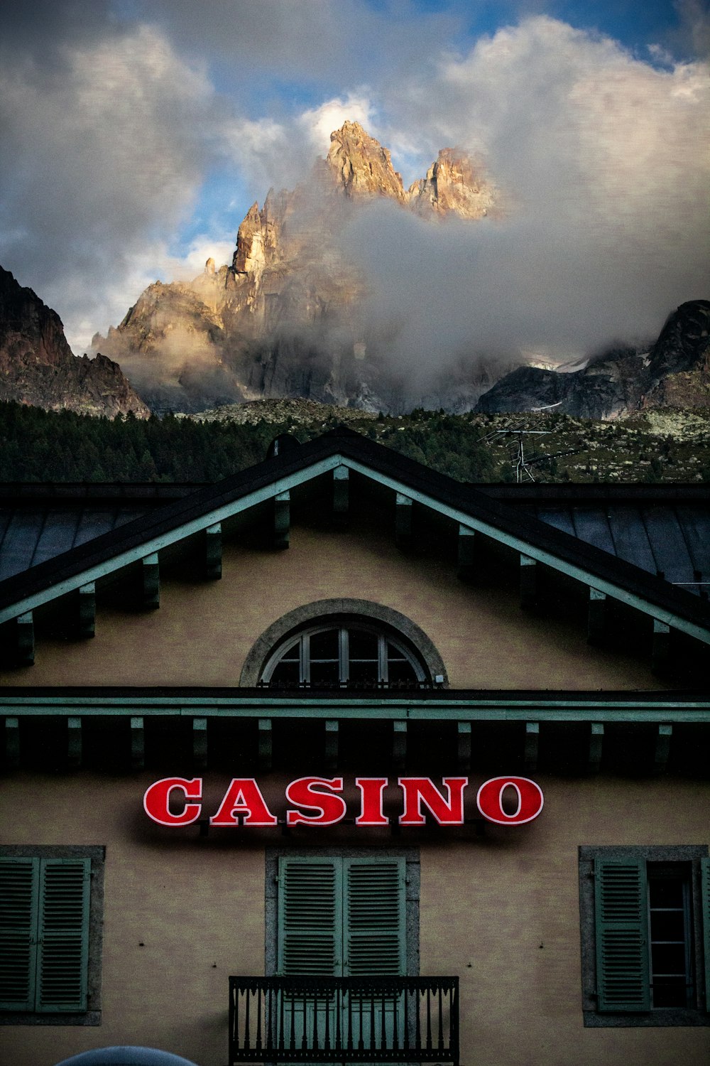 a building with a casino sign and mountains in the background