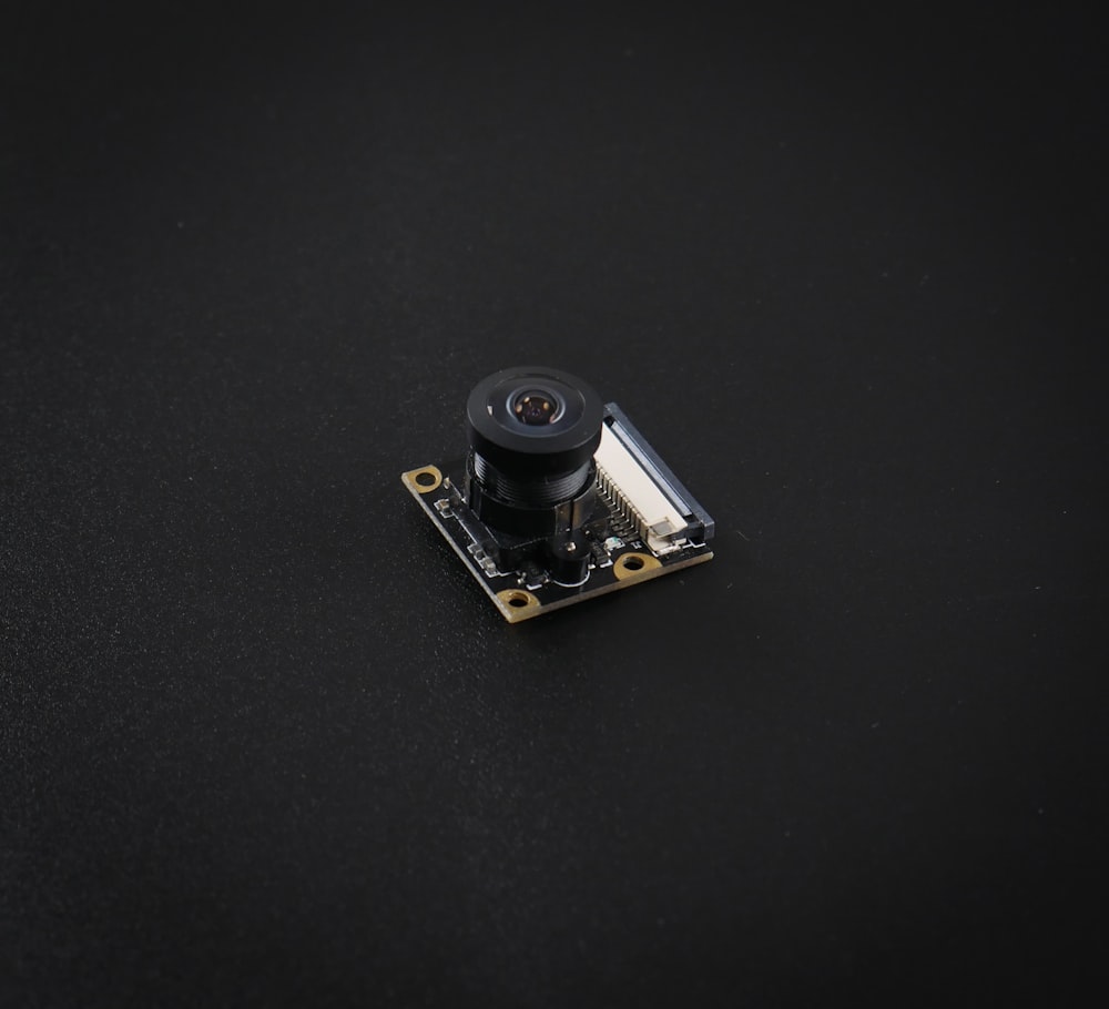 a small camera sitting on top of a black surface