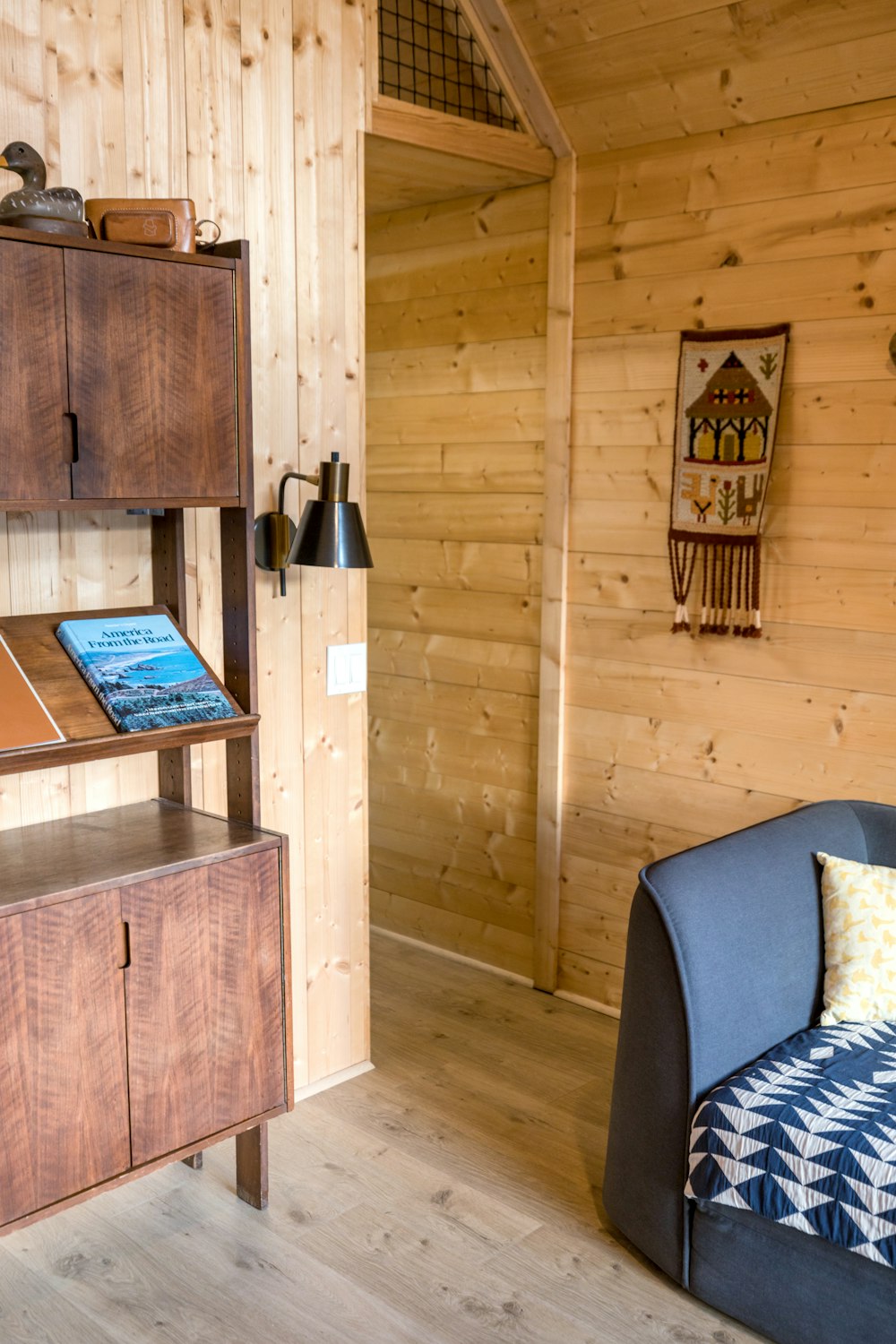 a room with wooden walls and a blue chair