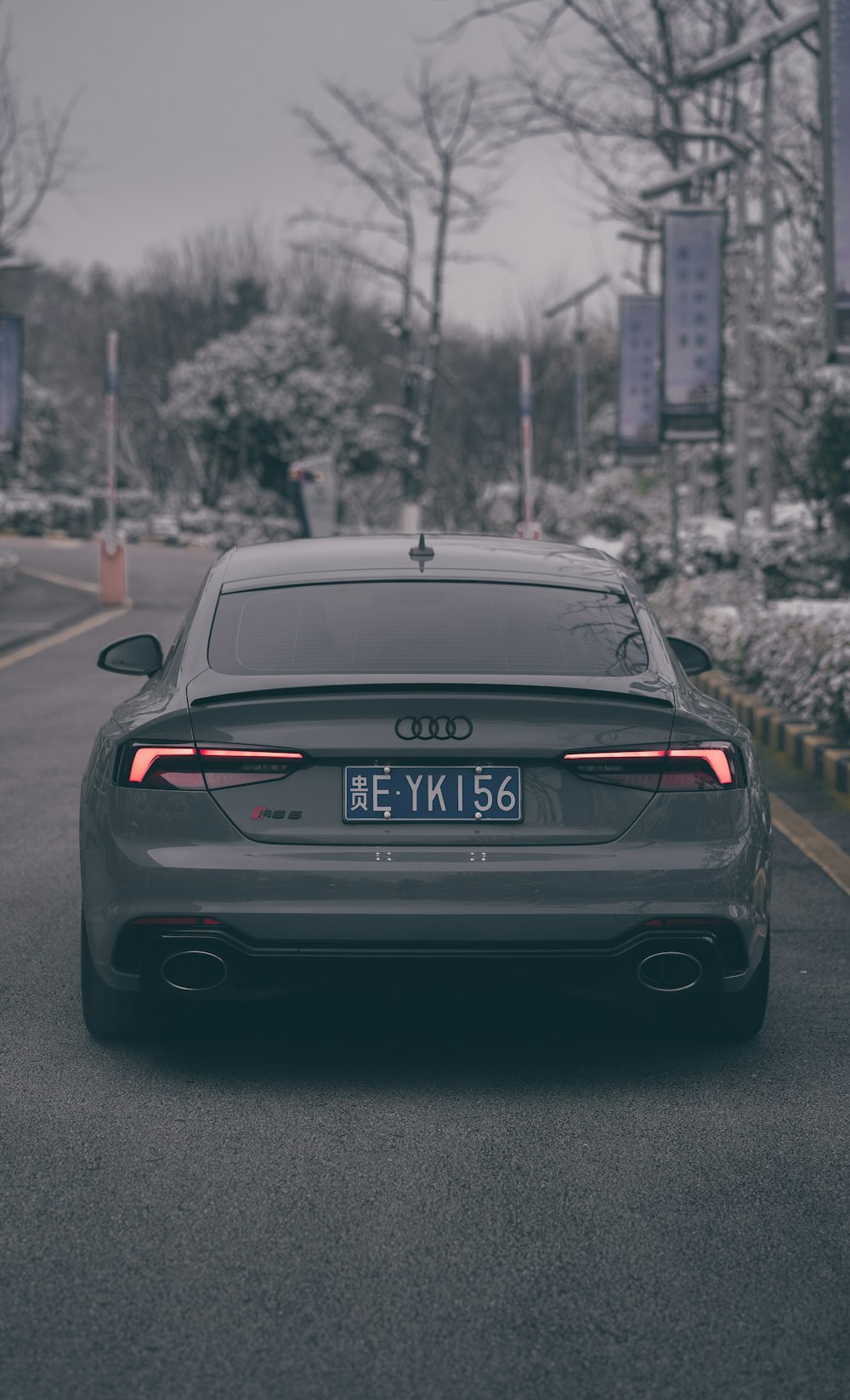 Un coche gris aparcado a un lado de la carretera