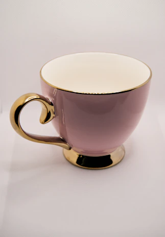 Close-up of a blush pink tumbler with gold accents and personalized name design.